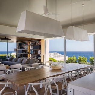 Sweeping sea views through floor-to-ceiling windows frame your open-plan living space, where modern comfort meets coastal elegance.
