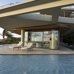 Modern villa features striking architecture with infinity pool and tropical landscape views.