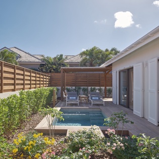 Step onto your private terrace where a sparkling pool awaits, surrounded by tropical blooms and shaded lounging spots for ultimate relaxation.
