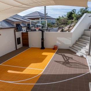 Your private basketball court awaits for friendly games under sunny skies, complete with professional hoop and vibrant court markings.