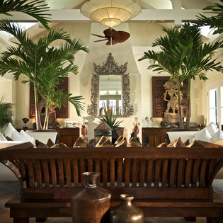 Sink into plush sofas surrounded by tropical palms and elegant Indonesian art in this sophisticated colonial-style lounge.