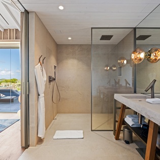 Luxurious bathroom with glass shower, double vanity, and pool views creates your perfect spa-like retreat.