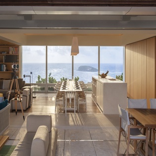 Your open-concept haven flows seamlessly from living to dining, where panoramic ocean views frame every meal and conversation through floor-to-ceiling windows.