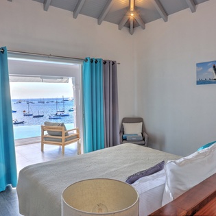 Wake up to breathtaking harbor views from your bed, where sailboats dot the turquoise waters beyond your private terrace.