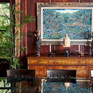 Your elegant dining space blends tropical sophistication with rich wood and stunning artwork, creating the perfect atmosphere for memorable meals.