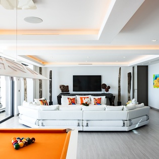 Unwind in your modern living space with plush seating, entertainment center, and fun pool table for memorable evenings.