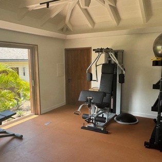 Your private fitness sanctuary awaits with professional-grade equipment and tropical garden views to energize every workout.