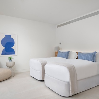 Unwind in your serene bedroom with crisp white linens, modern art, and thoughtful touches that create the perfect peaceful retreat.