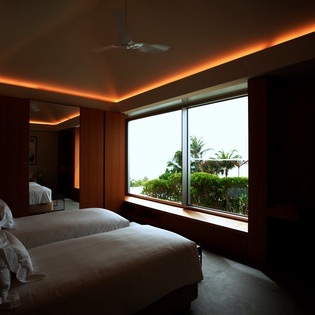 Drift off to sleep under warm ambient lighting while tropical palms sway outside your window, creating your perfect evening retreat.