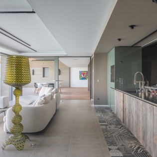 Your open-plan paradise blends sleek kitchen with living space, all framed by stunning ocean views through floor-to-ceiling windows.