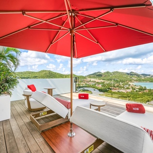 Relax on your private terrace with stunning views, comfortable loungers, and tropical shade for the perfect escape.