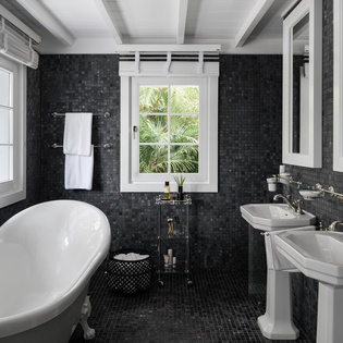 Indulge in your private spa retreat with elegant dual sinks and a luxurious soaking tub overlooking tropical gardens.