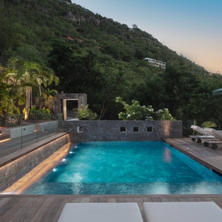 Slip into your private pool as twilight paints the sky, surrounded by lush tropical hills and luxurious amenities.