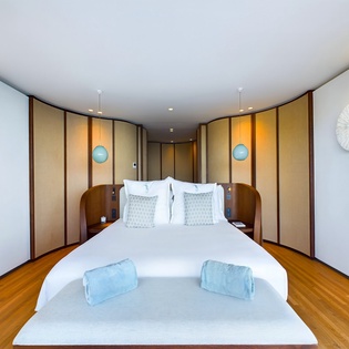 Sink into your elegant king bed surrounded by rich wood paneling and soft lighting that creates your perfect evening sanctuary.