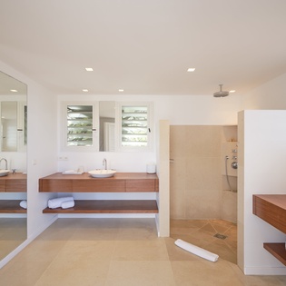 Your spacious bathroom features warm wood vanities, twin vessel sinks, and an elegant walk-in shower for ultimate relaxation.