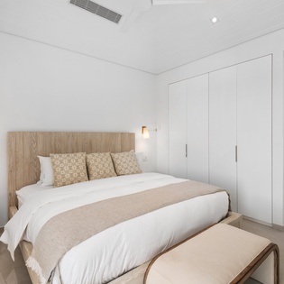 Unwind in your serene bedroom with ocean glimpses, plush linens, and thoughtful touches for your perfect getaway.