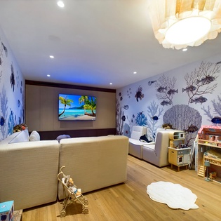 Dive into your underwater-themed family room, where ocean murals surround plush seating and kids' toys create magical playtime memories.