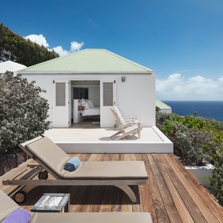 Stunning coastal retreat perched above crystal-blue waters. Relax on your private deck with ocean breezes, sunbathe on the loungers, and enjoy direct bedroom access to breathtaking sea views.