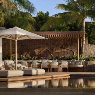 Your tropical sanctuary awaits with plush poolside loungers and dining beneath swaying palms, perfect for memorable evenings.