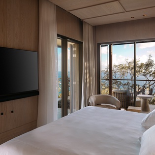 Wake up to stunning sea views from your elegant bedroom, where floor-to-ceiling windows frame the ocean perfectly.
