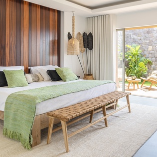Your serene bedroom sanctuary features a stunning wood accent wall and garden views that invite peaceful mornings.
