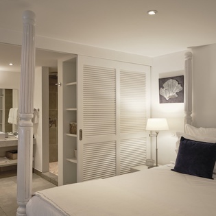 Sink into crisp white linens in your elegant bedroom, where nautical touches and soft lighting create a peaceful retreat for restful nights.