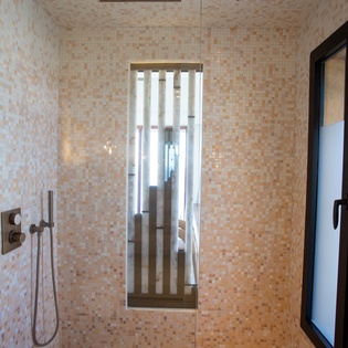 Your spa-like bathroom features luxurious mosaic tiles, a rainfall shower, and elegant modern fixtures for ultimate relaxation.