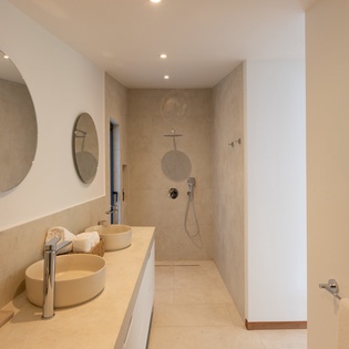 Step into your serene spa-like bathroom featuring dual vessel sinks, rainfall shower, and elegant earth-tone finishes for ultimate relaxation.