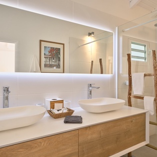 Refresh in your elegant bathroom featuring dual vessel sinks, rainfall shower, and thoughtful amenities for a spa-like experience.