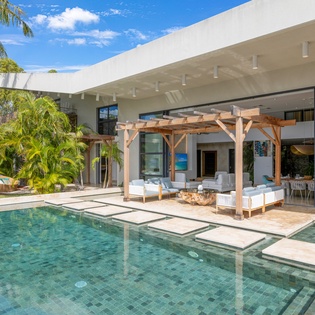 Step into your private oasis where crystal-clear waters invite you to unwind beneath swaying palms and endless blue skies.