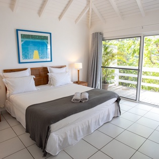 Drift off to sleep in your bright bedroom with crisp linens and wake to lush tropical views through floor-to-ceiling windows.