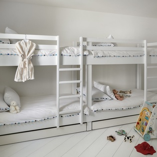 Your little ones will love this cheerful bunk bed room with soft linens and fun toys waiting for bedtime stories.