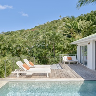 Your private pool deck awaits with sun loungers overlooking lush tropical gardens and rolling hillside views.