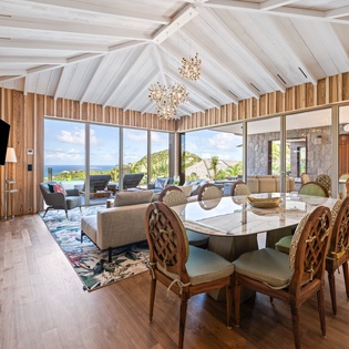 Unwind in this stunning open-plan living space where vaulted ceilings and panoramic ocean views create your perfect island retreat.