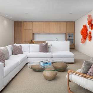 Sink into plush white sectional seating while you soak up the modern elegance of this open-plan living space.