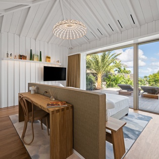 Unwind in your bright, modern bedroom with vaulted ceilings and direct terrace access to tropical views.