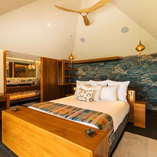 Sink into plush pillows and drift off beneath soaring vaulted ceilings. Your private retreat features a bunk nook for extra guests, warm wood accents, and bold botanical wallpaper that brings nature indoors.