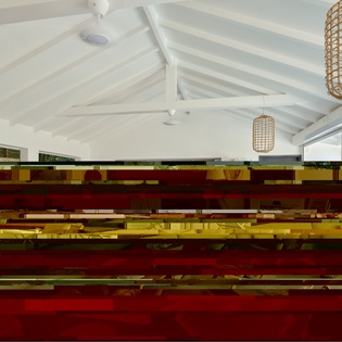 Relax in your stylish living space with vaulted ceilings, woven pendant lights, and colorful artistic accents creating a warm, contemporary atmosphere.