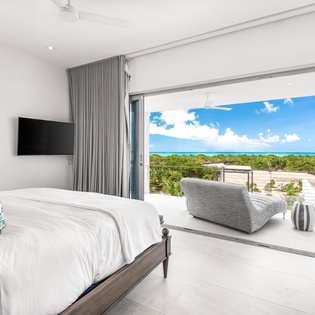 Wake to stunning ocean views from your private bedroom sanctuary, where floor-to-ceiling windows frame tropical paradise beyond.