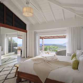 Wake up to breathtaking views through floor-to-ceiling windows while lounging in your beautifully appointed bedroom with vaulted ceilings and modern amenities.