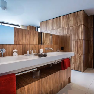 Slip into your private spa-like bathroom with sleek floating vanities, warm wood tones, and abundant natural light streaming through oversized windows—your serene escape awaits.