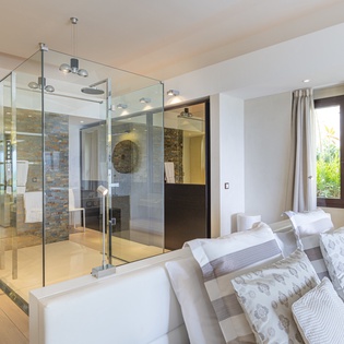Bright and open suite where your elegant bedroom flows into a stylish glass-enclosed shower spa, blending comfort with luxurious modern design.