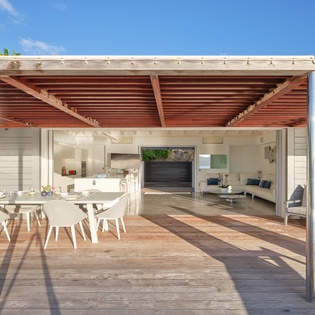 Step into your open-plan haven where modern kitchen, dining, and living spaces flow seamlessly under a stylish pergola, perfect for indoor-outdoor living.