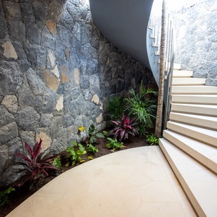 Your private stairway features stunning stone walls and tropical plants, creating a unique botanical journey to your room.