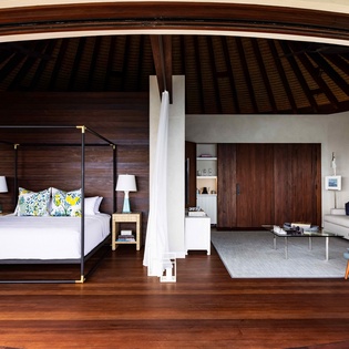 Step into your tropical haven where rich wood floors meet soaring ceilings, creating a space that feels both luxurious and warmly intimate.