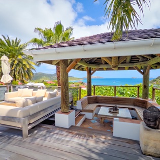 Your private outdoor oasis awaits: sink into plush lounge seating while gazing at turquoise waters and lush tropical hills. Perfect for relaxing or sipping morning coffee in paradise.