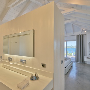 Your luxurious suite features a spa-like marble vanity and stunning sea views from your private bedroom, creating the perfect coastal retreat.
