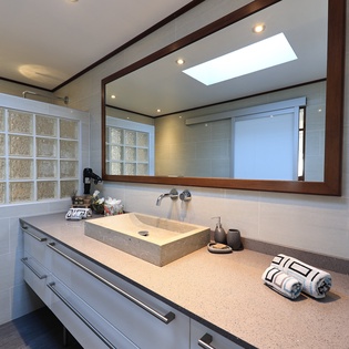 Indulge in your private spa-like bathroom with elegant stone counters, perfect lighting, and luxurious amenities for your ultimate relaxation.