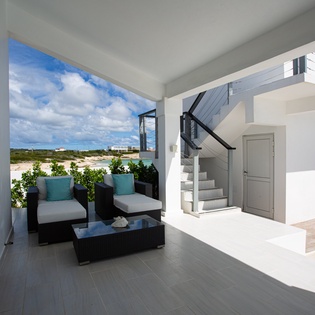 Your private terrace opens to coastal beauty, with plush seating overlooking sandy shores and turquoise waters—a serene spot to savor morning coffee or sunset moments.