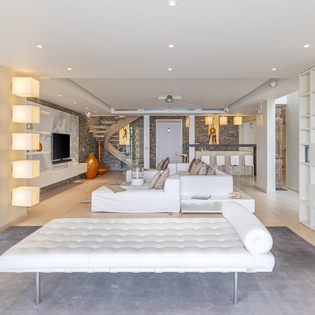 Step into an elegant, light-filled space where modern design meets artistic flair. Relax on plush seating surrounded by warm textures, sculptural accents, and sleek contemporary style—your stylish retreat awaits.